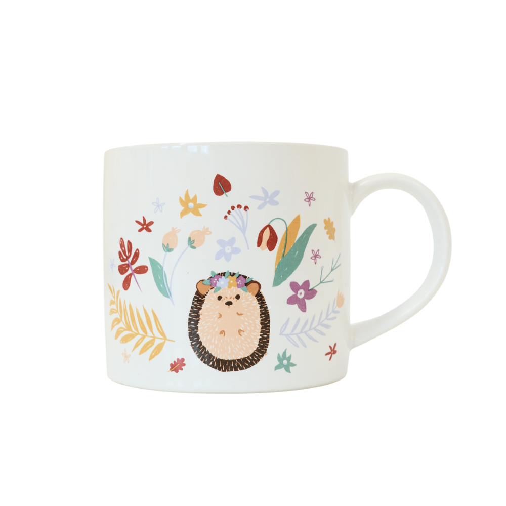white mug with an illustrated hedgehog, surrounded by different illustrated plants