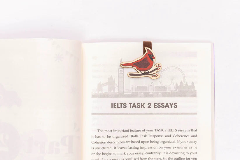 wood cardinal sitting on a branch on a page about essays