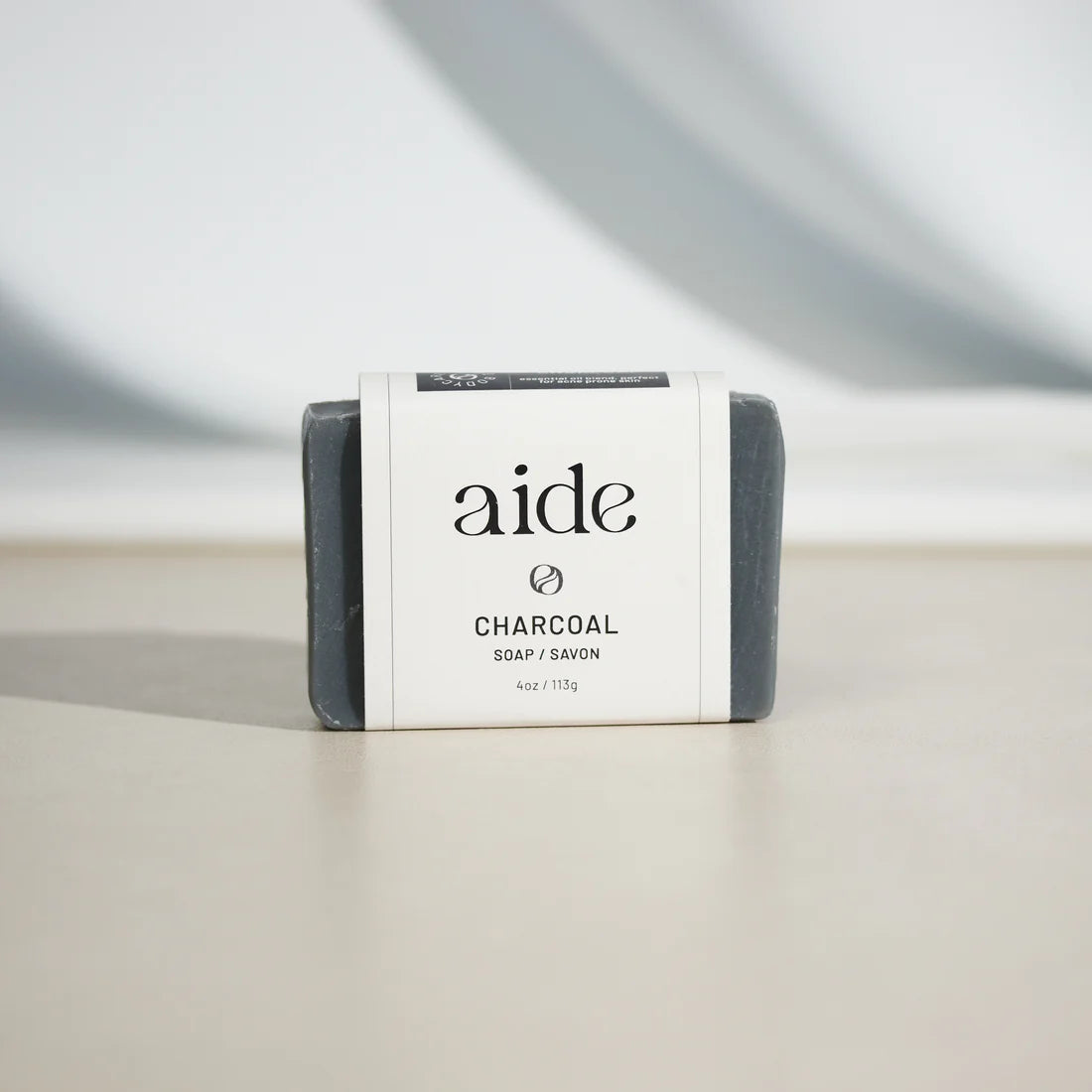 grey bar of soap with a white band label with black text