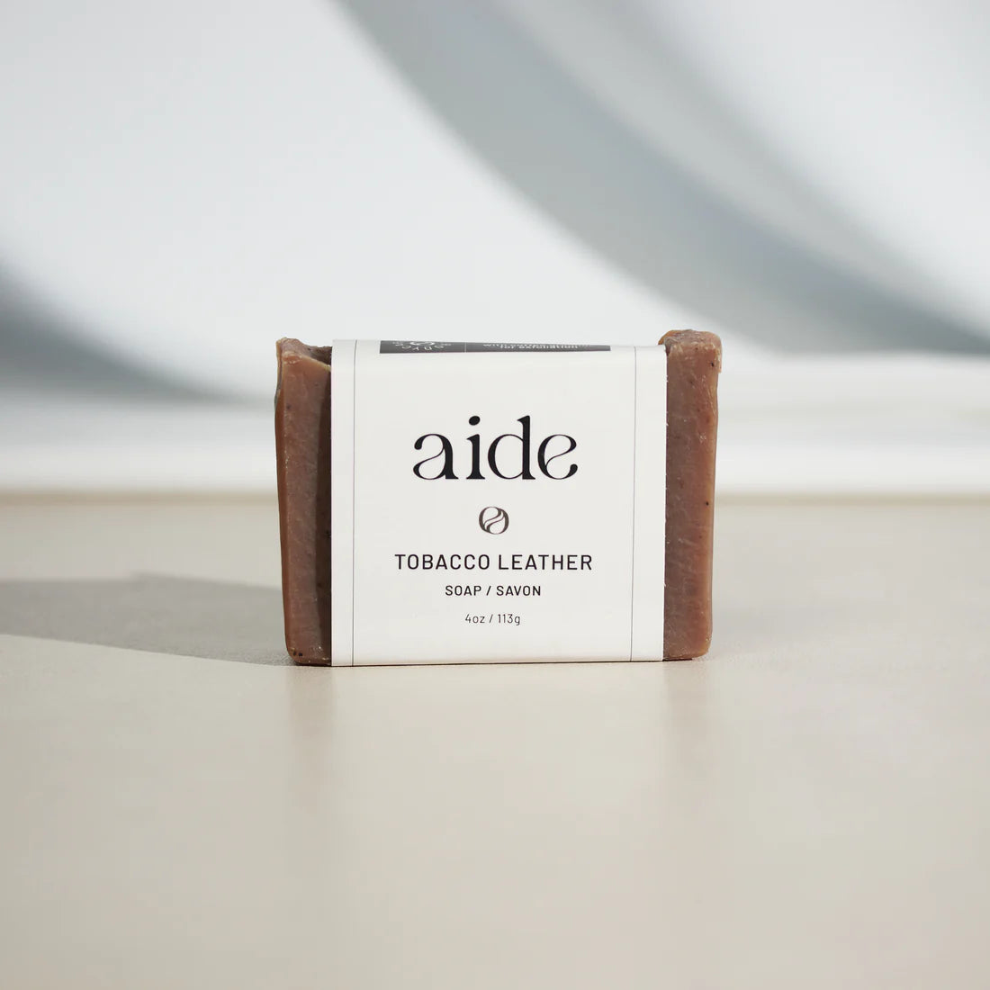reddish-brown bar of soap with a white band label