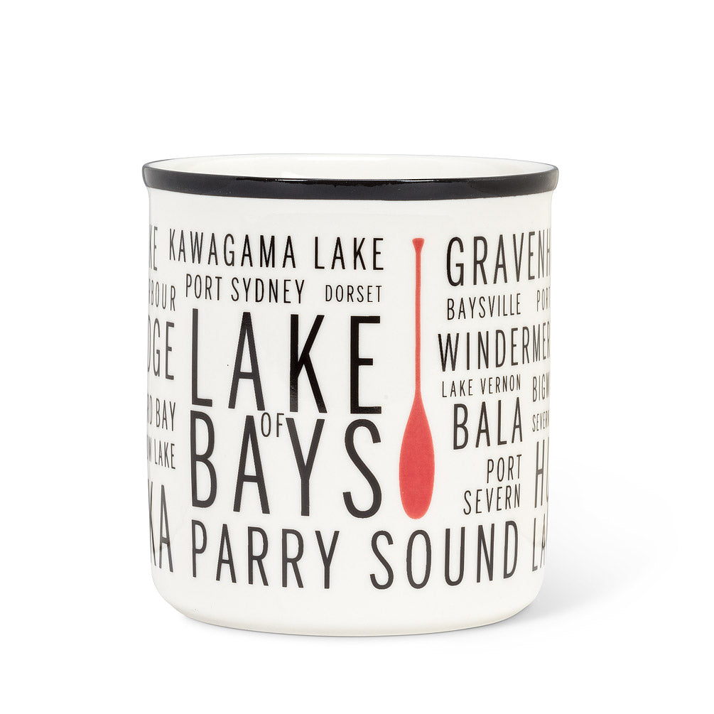 white mug and with a black rim, with different sied text of different areas in cottage country and a red paddle