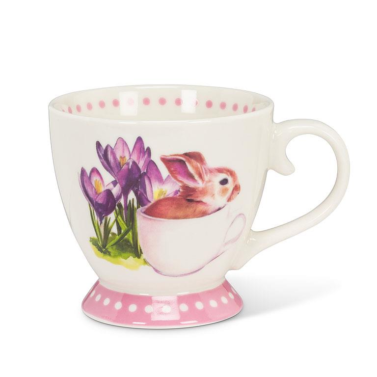 pink and white teacup with a small bunny in a tea cup with purple flowers painted on the mug