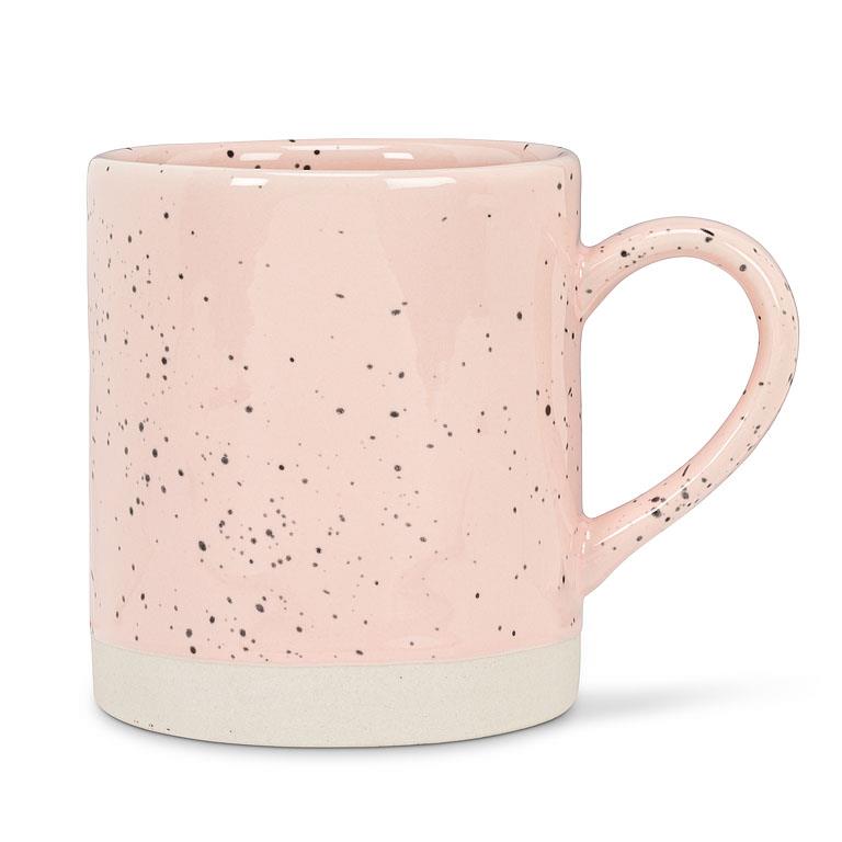 Light pink mug with a white base, and spots of black across the mug