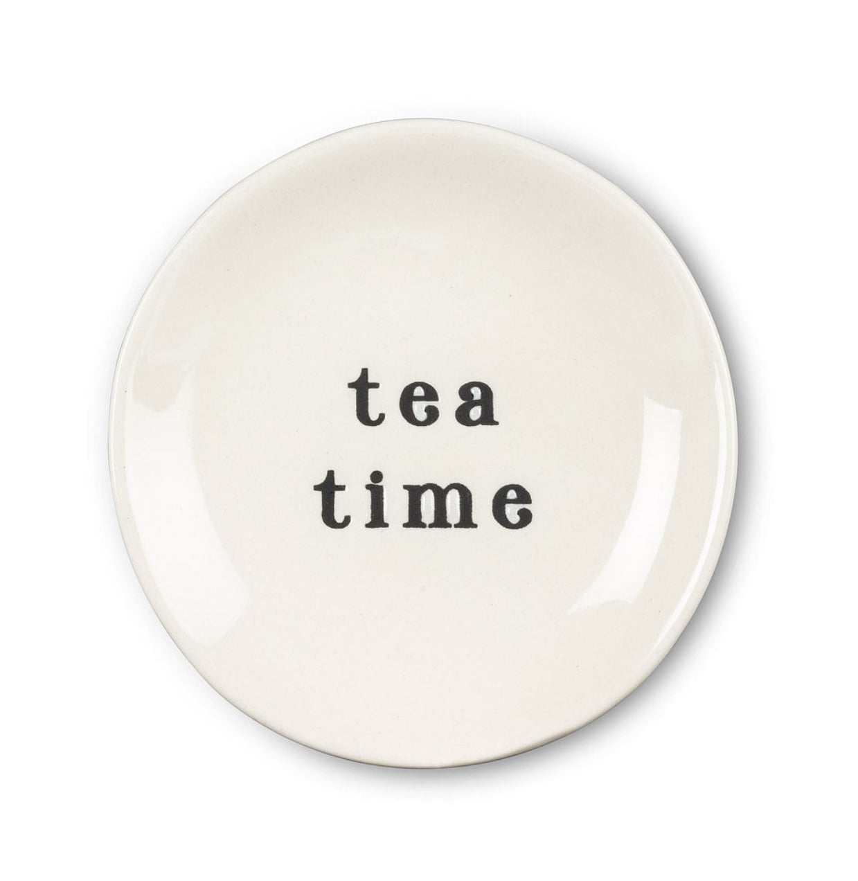 Round white plate with black font that says tea time