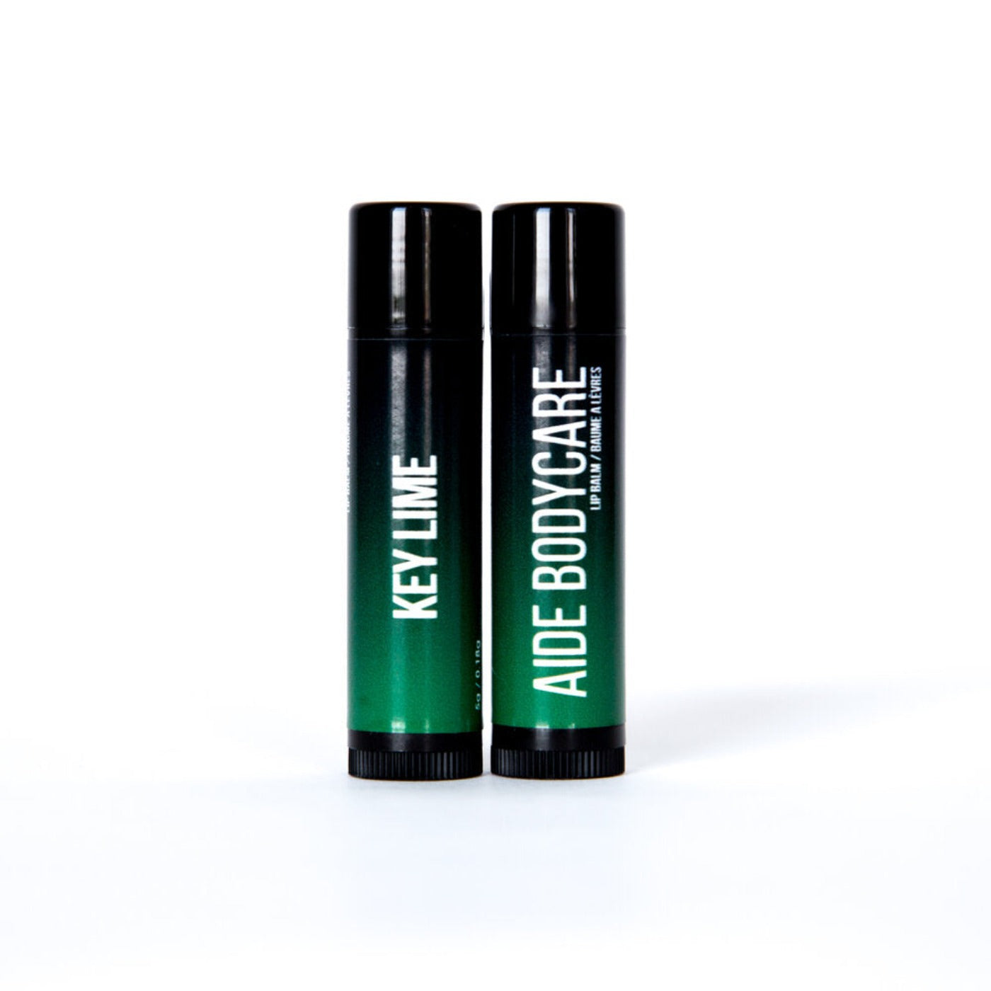 side by side lip balm containers that have a black to green gradient, and text that reads "key lime" on one, and "Aide bodycare" on the other