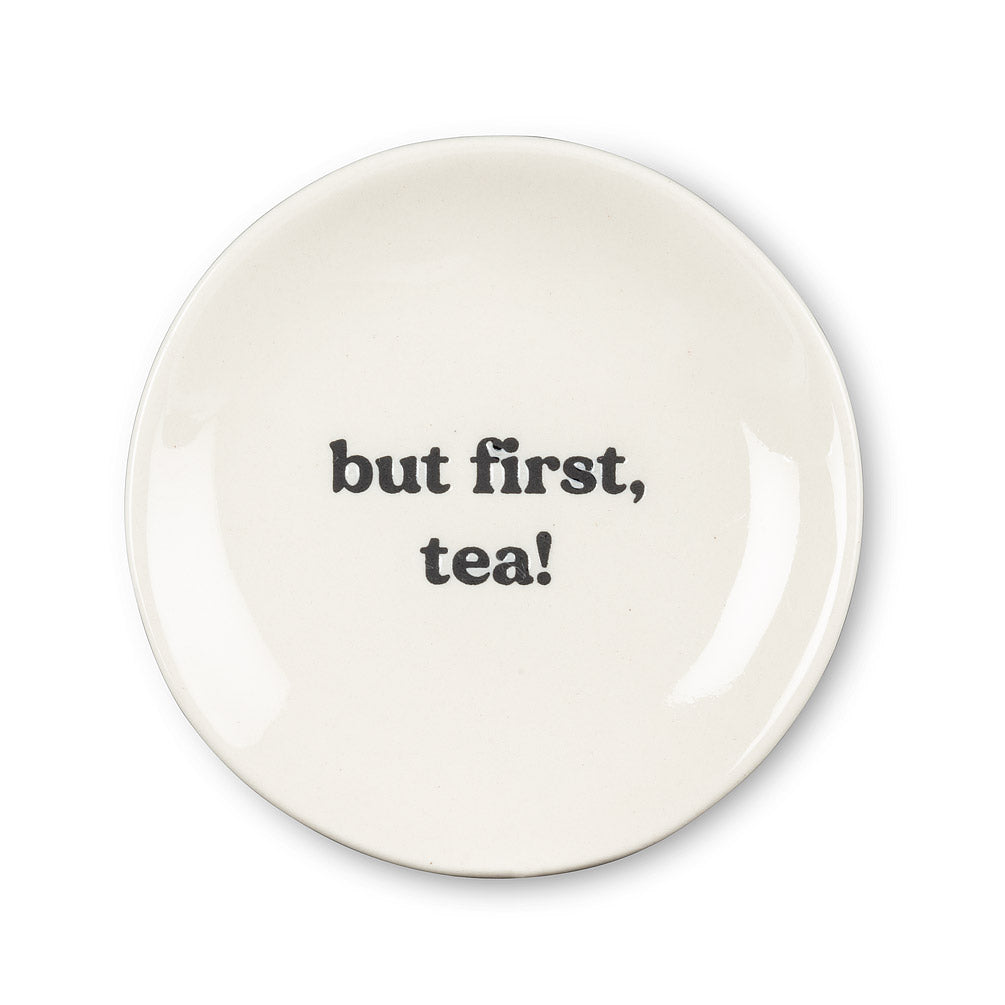 round white plate with but first, tea! In black font in the centre