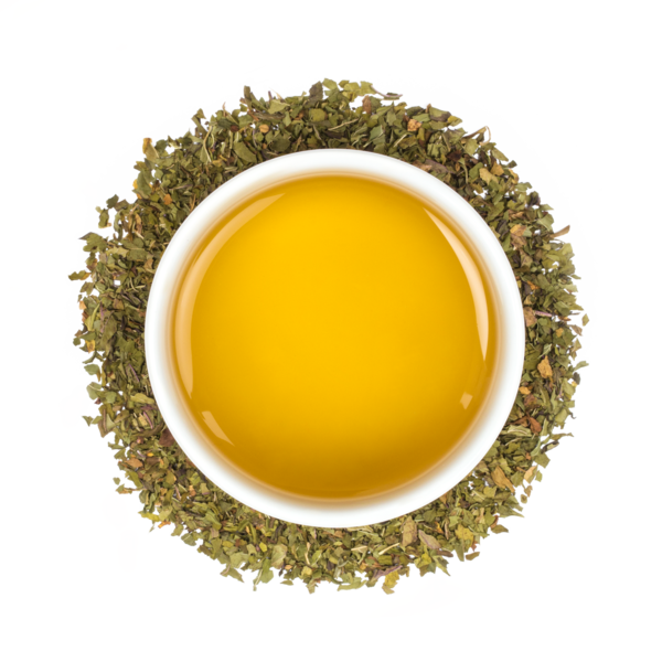 yellow tea in a white tea mug surrounded by green tea leaves
