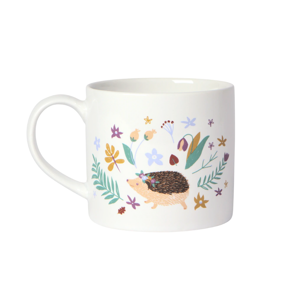 white mug with an illustrated hedgehog in a different pose, surrounded by different illustrated plants