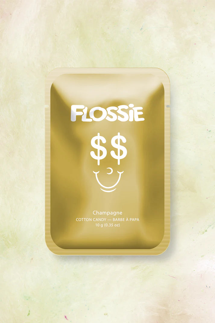 gold metallic packaging with white text that reads "flossie" with a smiling face that has dollar signs for eyes