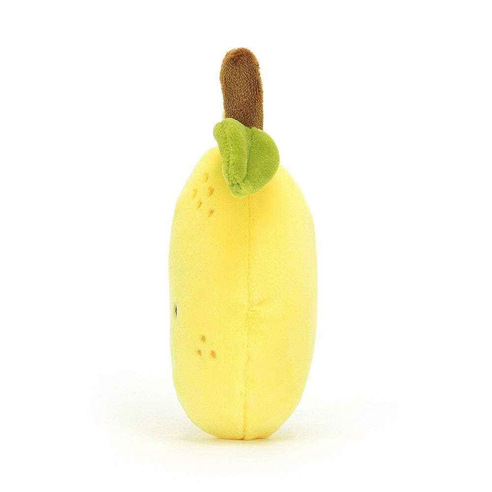 side view of a plush light yellow lemon with green leaves and a brown stem
