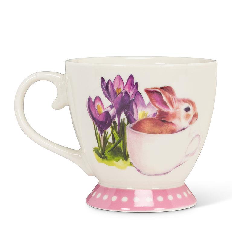 pink and white teacup with a small bunny in a tea cup with purple flowers painted on the mug