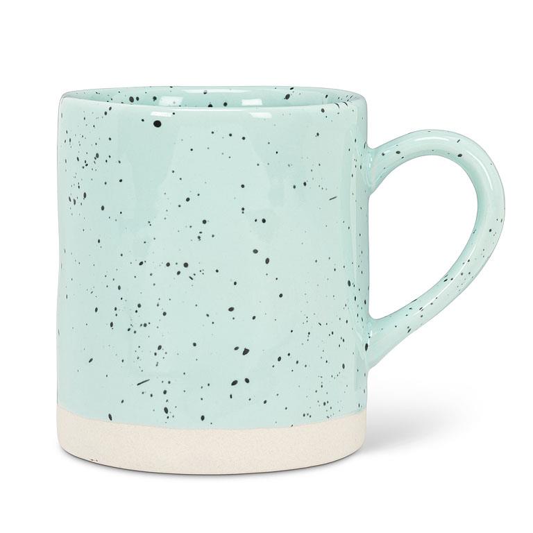 Light blue mug with a white base, and spots of black across the mug