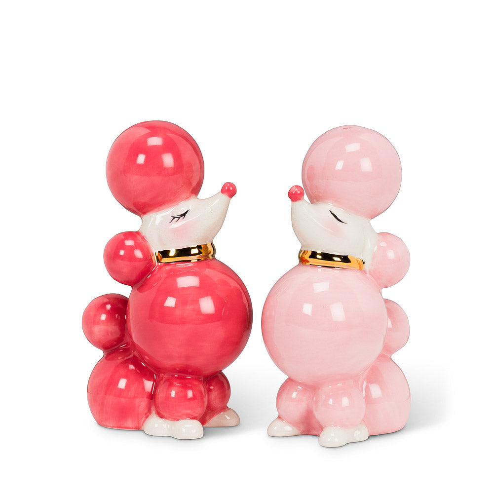 two salt and pepper shakers in the shape of cartoonish poodles, with one being magenta, and the other being light pink