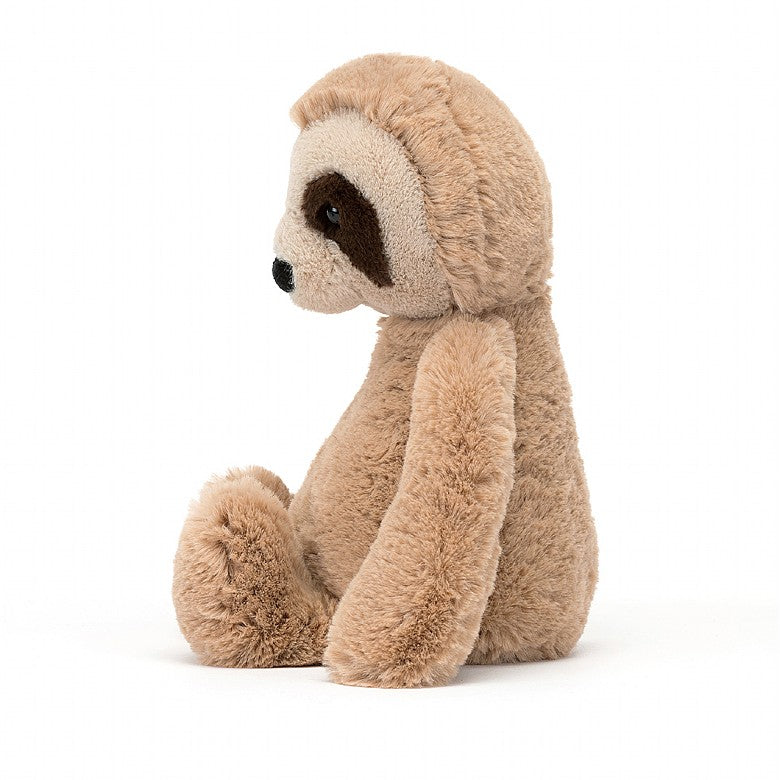 side view of a plush light brown sloth with an off-white face, and brown circles around the eyes