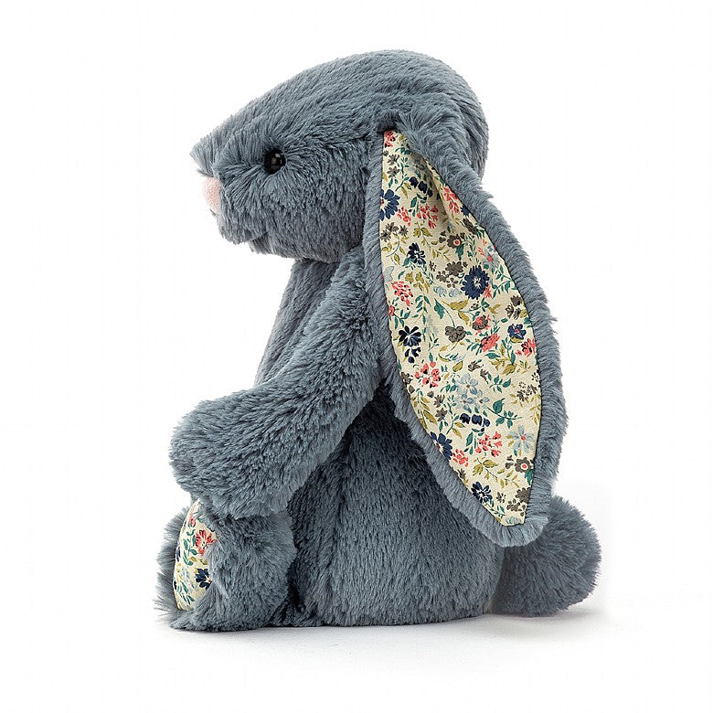Side view of a bluish grey bunny with an multicoloured flower pattern on the bottom of the feet and the inner ears