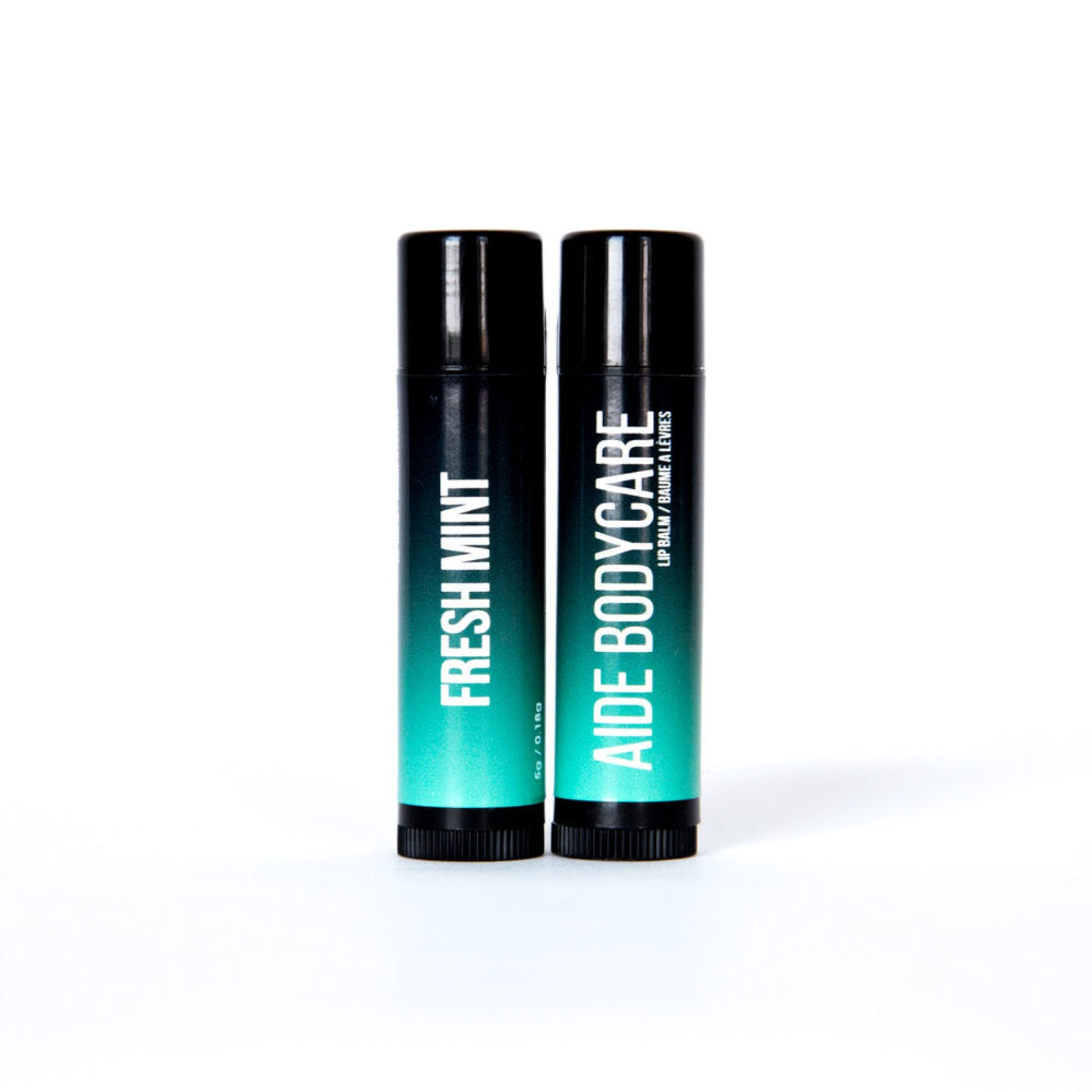 Lip balm with a black to teal gradient and text that says "Fresh Mint" on one side and "Aide Bodycare" on the other