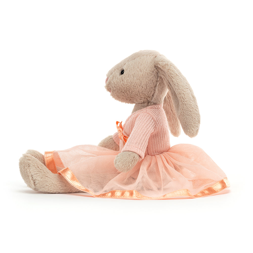 side view of a grey fluffy plush bunny wearing a pink dress