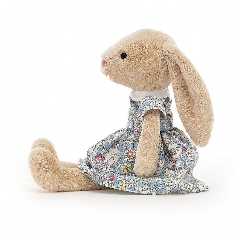 Side view of a light beige plush fluffy bunny rabbit wearing a light blue floral city 