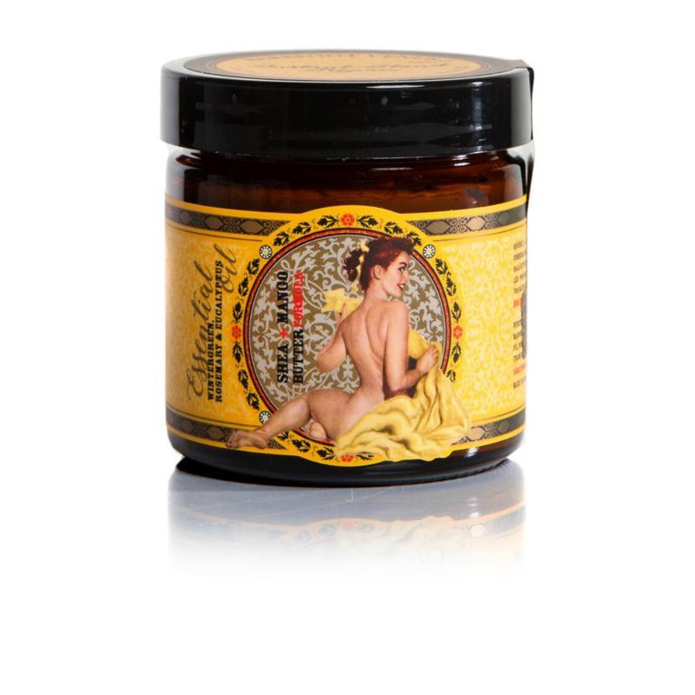 Black hand cream container with a yellow, and gold label with an intricate circular design that has a pin-up model holding a yellow blanket 