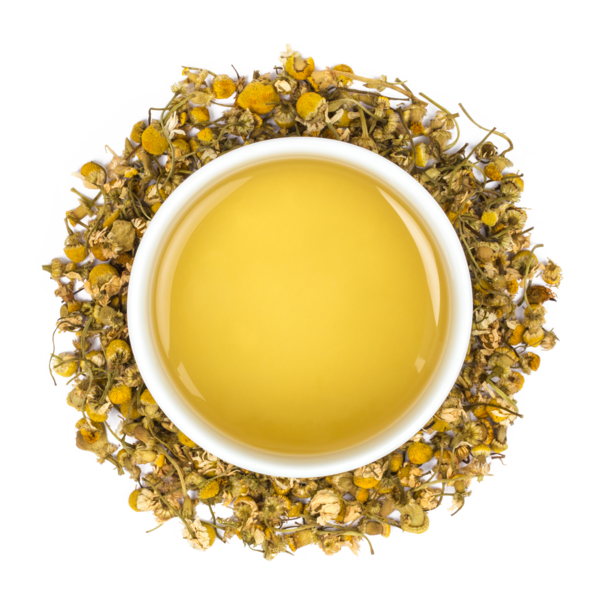 yellow tea in a white mug surrounded by light brown tea leaves 