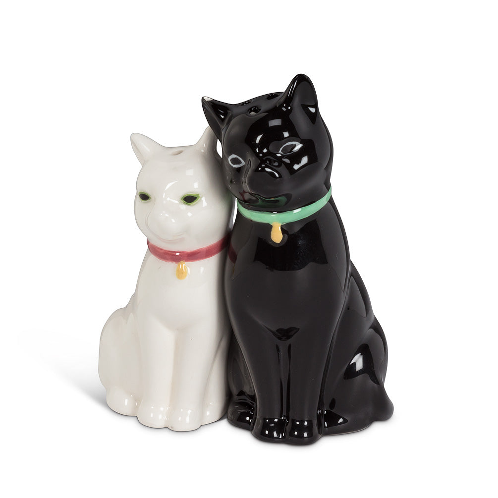 Salt and pepper shakers in the shape of cats, one slightly larger, and black with a green collar, the other is smaller, and white with a red collar.