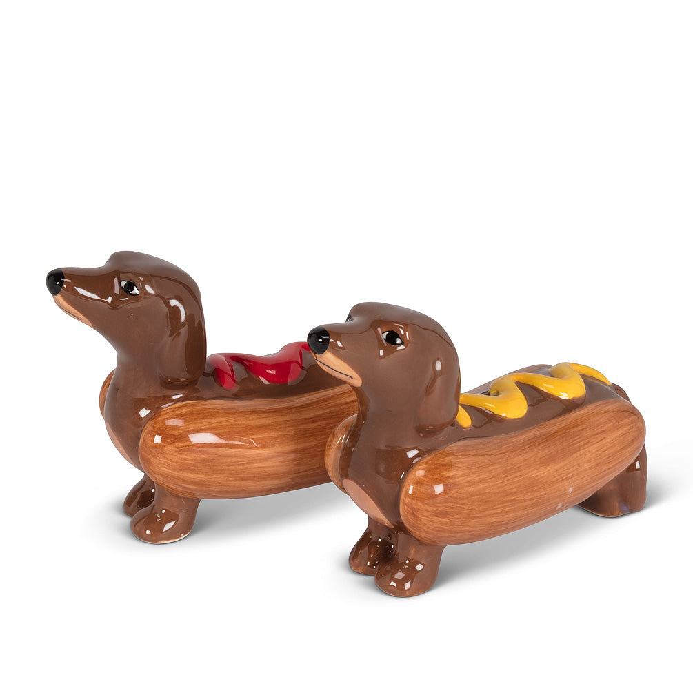 salt and pepper shakers in the shape of brown dachshund  dogs in hot dog buns, with one dressed in ketchup and one dressed in mustard