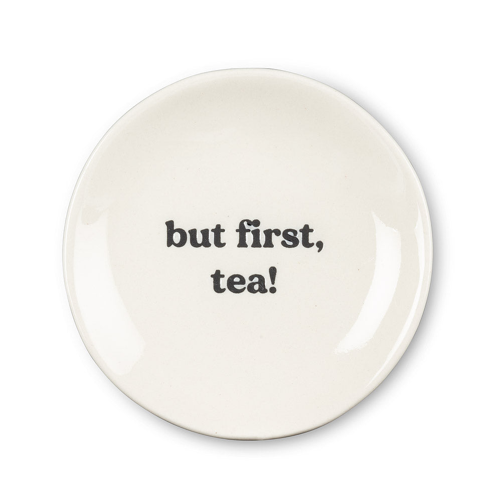 round white plate with but first, tea! In black font in the centre 