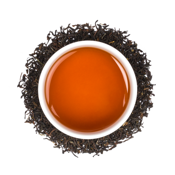 overhead shot of red tea in a white mug, surrounded by the tea leaves