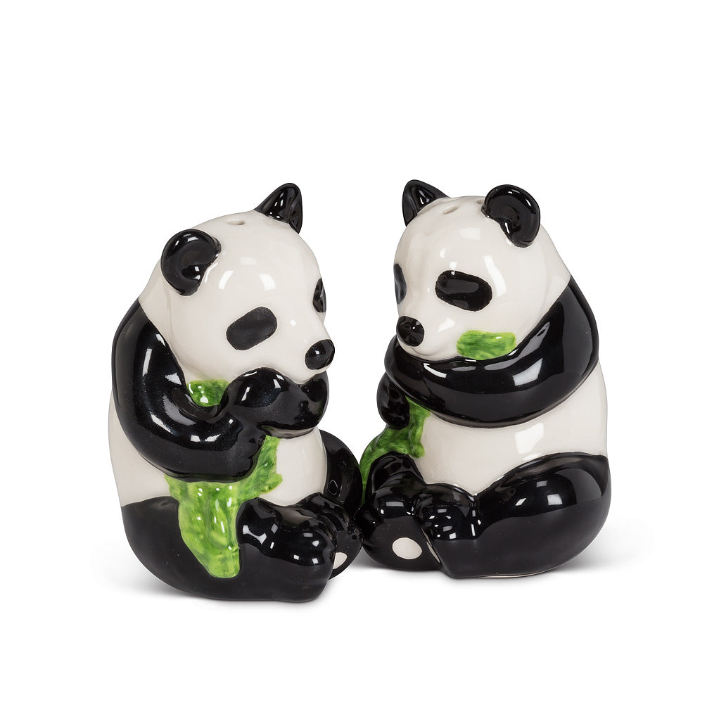 two salt and pepper shakers in the shape of pandas holding green leaves