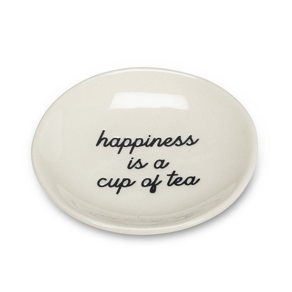 Side angle of round white plate with black cursive font that says happiness is a cup of tea